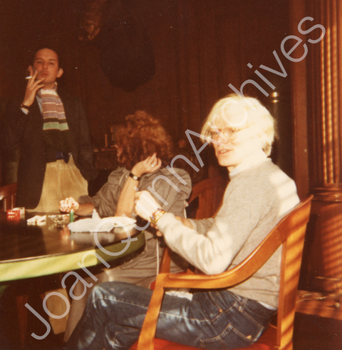 Andy Warhol Putting a Bracelet on with Fred Hughes & Suzie Frankfurt in the Background